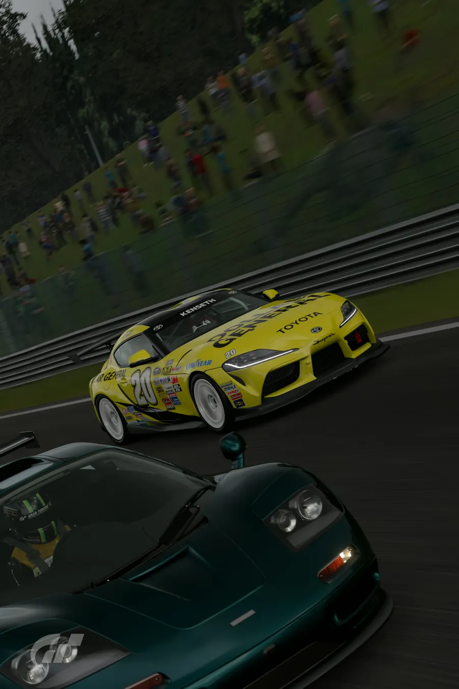 A yellow number 20 race car battling a dark green supercar in front of a crowd